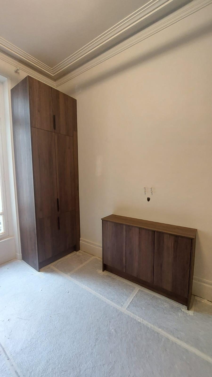 Dressing toute hauteur et enfilade basse en placage noyer dans une pièce ancienne à corniche moulurée