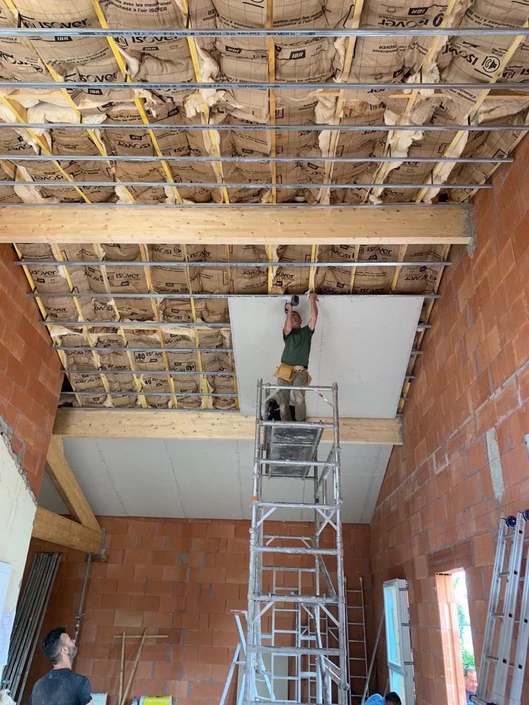 Isolation sous rampants, plaquage en grande hauteur · chantier des équipes partenaires