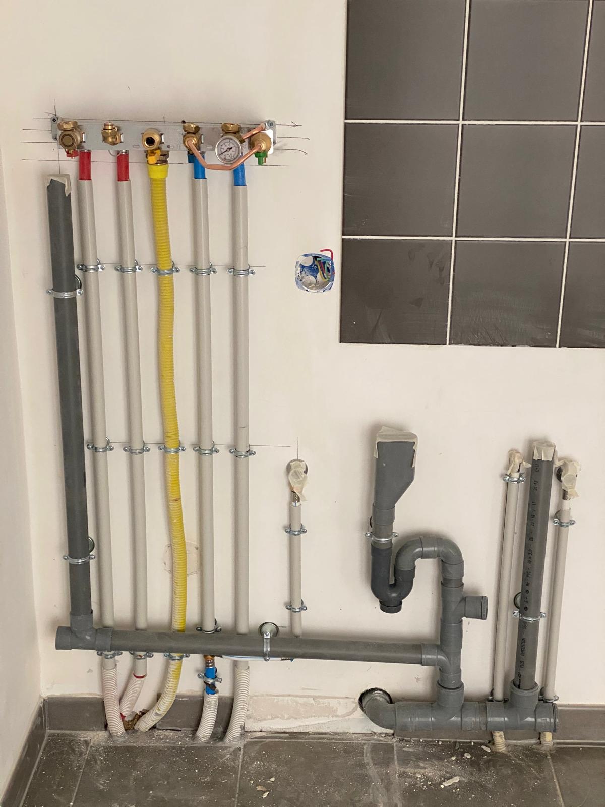 Nourrice de plomberie avec manomètre pour l'essai de mise en pression, évacuations PVC à côté