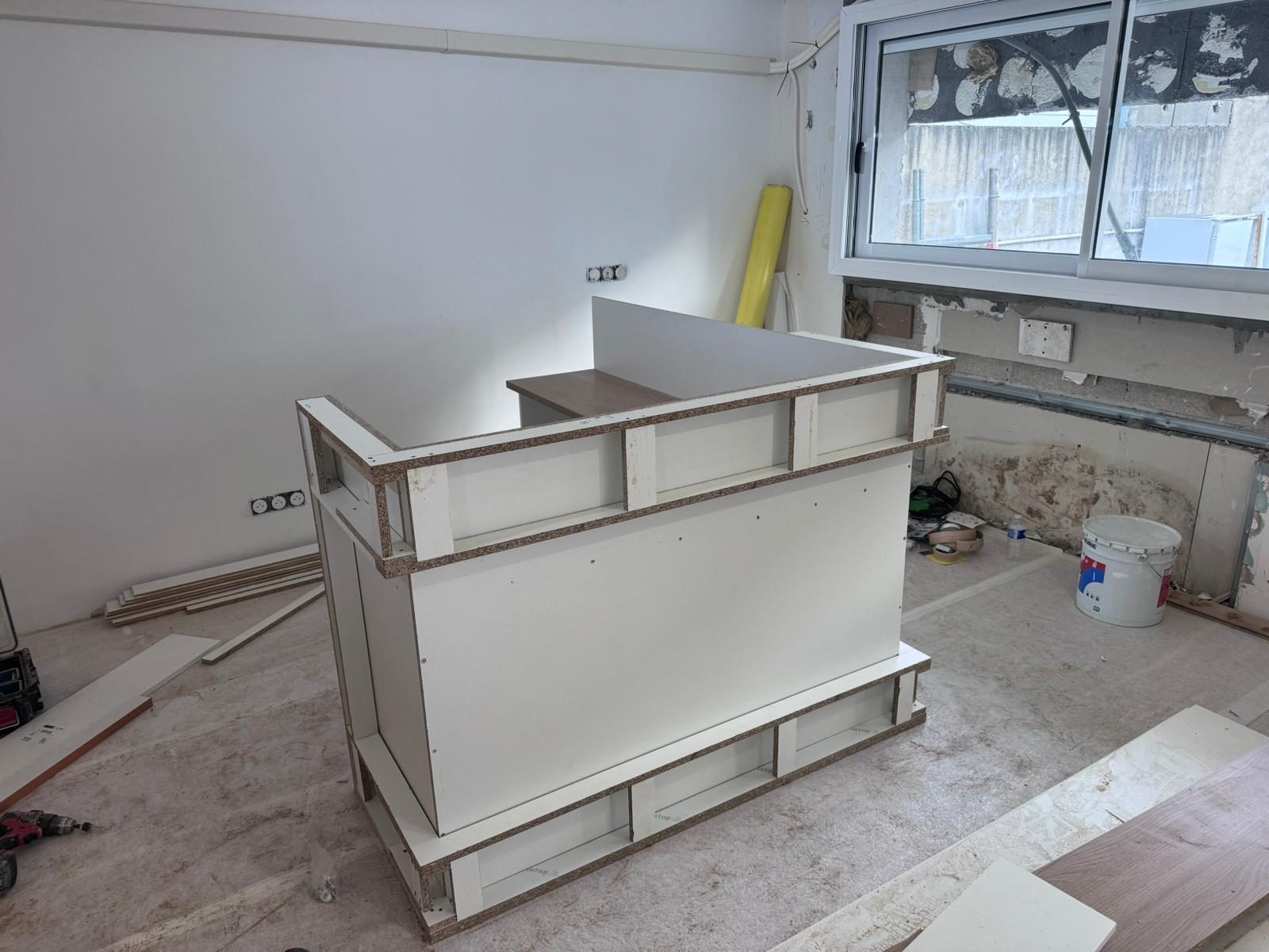 Local commercial en travaux : carcasse brute du comptoir d'accueil montée sur site