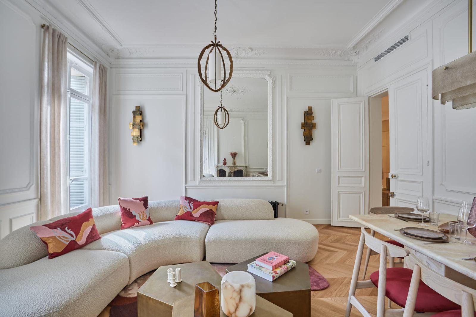 Salon rénové entièrement : trumeau à miroir, appliques dorées, moulures restaurées et parquet à chevrons