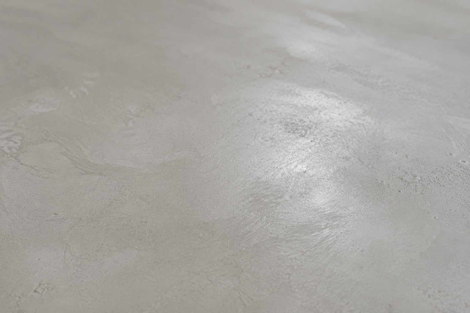 Gros plan sur la texture du béton ciré, surface minérale continue sans joint