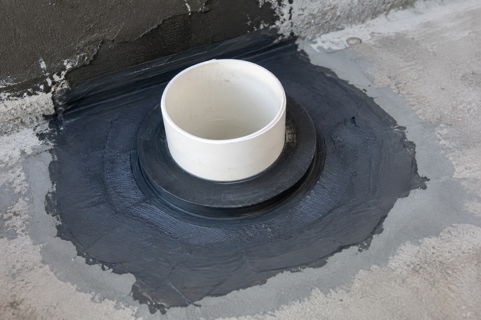 Illustration pédagogique : traversée de canalisation traitée par une collerette noyée dans le système d'étanchéité, et non par un simple joint appliqué en surface. Image de principe, pas un chantier des équipes partenaires.